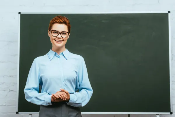 happy-teacher-in-eyeglasses-looking-at-camera-whil-2026-01-05-23-58-04-utc-697b9b1662123